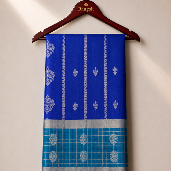 Elevate your ethnic style with this elegant royal blue silk saree, featuring intricate silver zari motifs and a striking teal checked contrast border.