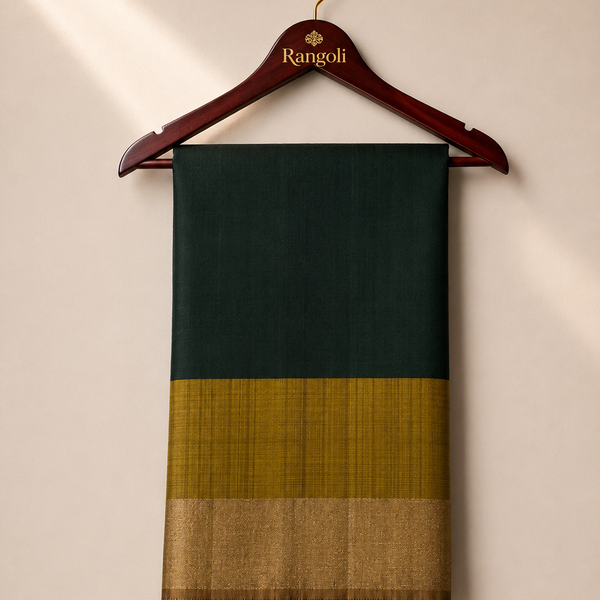 Embrace timeless elegance with this rich dark green silk saree, beautifully finished with a lustrous gold zari contrast border for a graceful traditional look.