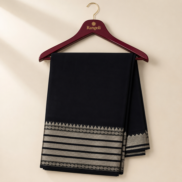 Elegant black saree featuring a rich silver woven zari border with timeless traditional detailing for a graceful and sophisticated look.