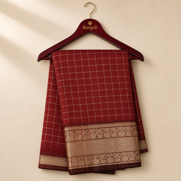 Elegant maroon checked saree featuring a rich gold zari woven border with intricate traditional motifs for a timeless festive look.
