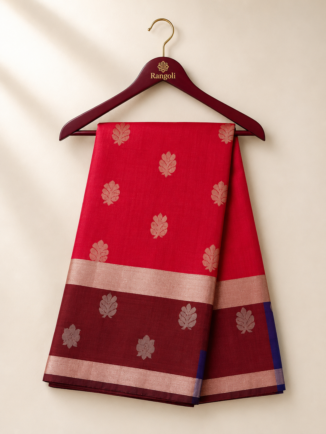 Graceful crimson red silk saree featuring elegant silver zari leaf motifs and a rich maroon zari border for a timeless traditional appeal.