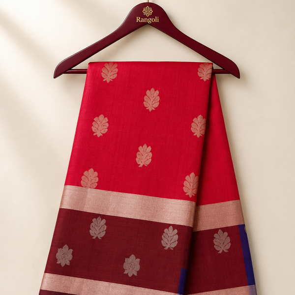 Graceful crimson red silk saree featuring elegant silver zari leaf motifs and a rich maroon zari border for a timeless traditional appeal.