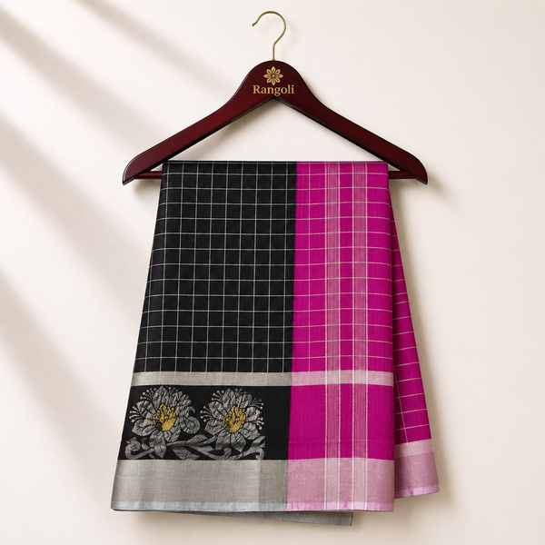 Elegant black silk saree featuring a classic white checkered weave with a sophisticated silver zari floral border for a timeless traditional look.