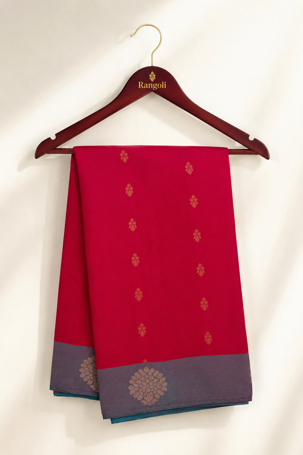 Radiate timeless elegance with this vibrant crimson uppada saree featuring delicate gold zari buttas and a sophisticated contrasting grey zari border.