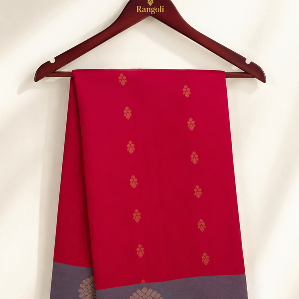 Radiate timeless elegance with this vibrant crimson uppada saree featuring delicate gold zari buttas and a sophisticated contrasting grey zari border.