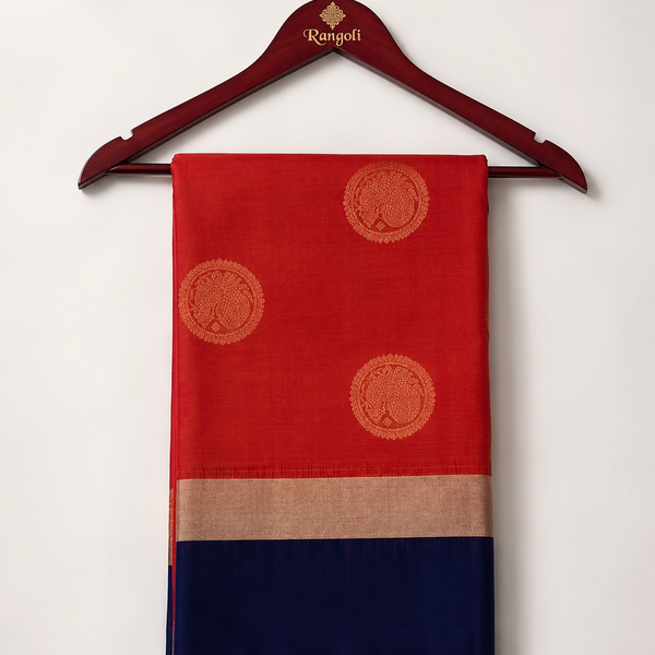 Graceful orange Kanchipattu silk saree featuring elegant gold zari buttas with a rich navy blue zari border for a timeless traditional look.