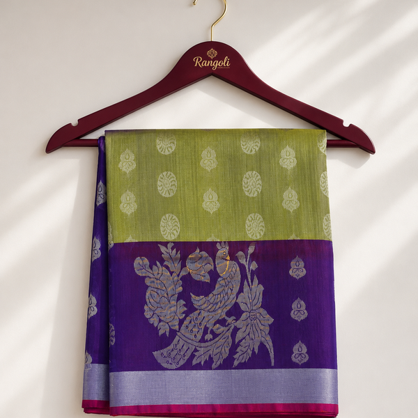 Olive Green Kanchipattu Silk Saree featuring elegant silver zari buttas with a rich purple peacock zari border for a timeless traditional look.