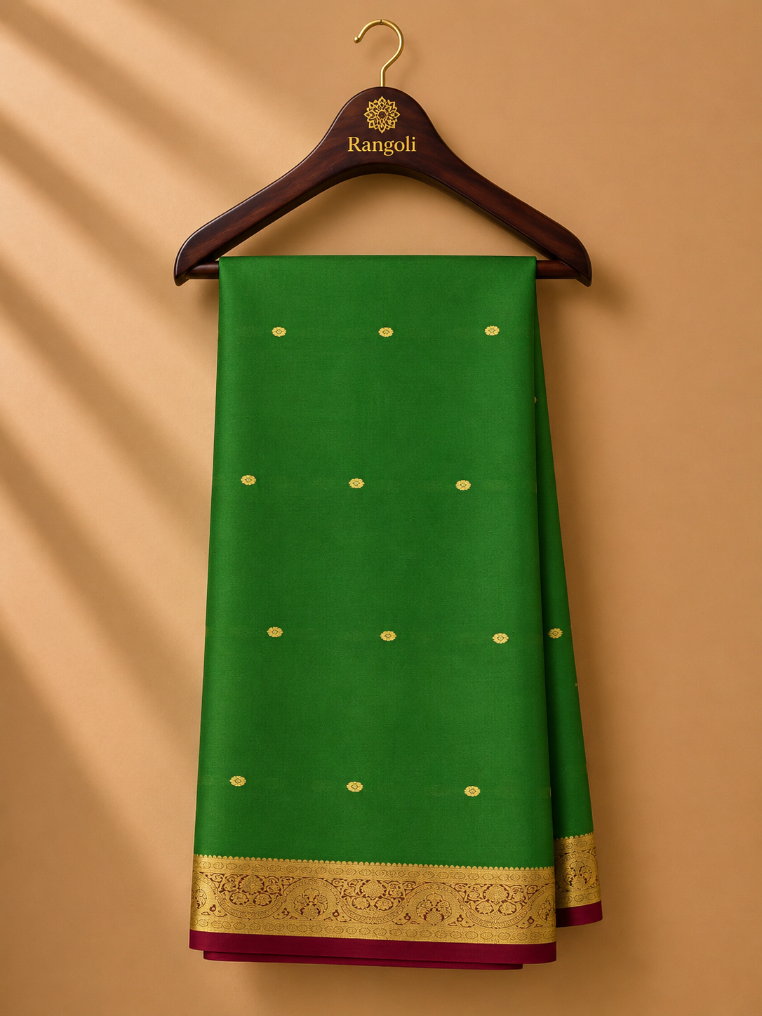 Graceful leaf green Kanchipattu silk saree adorned with delicate gold zari buttas and a rich maroon-gold traditional zari border.