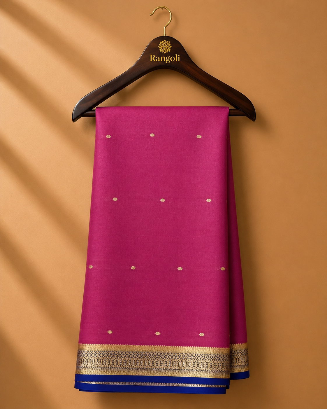Vibrant magenta Mysore Silk saree featuring delicate gold zari buttas and a contrasting royal blue zari border for a timeless traditional appeal.