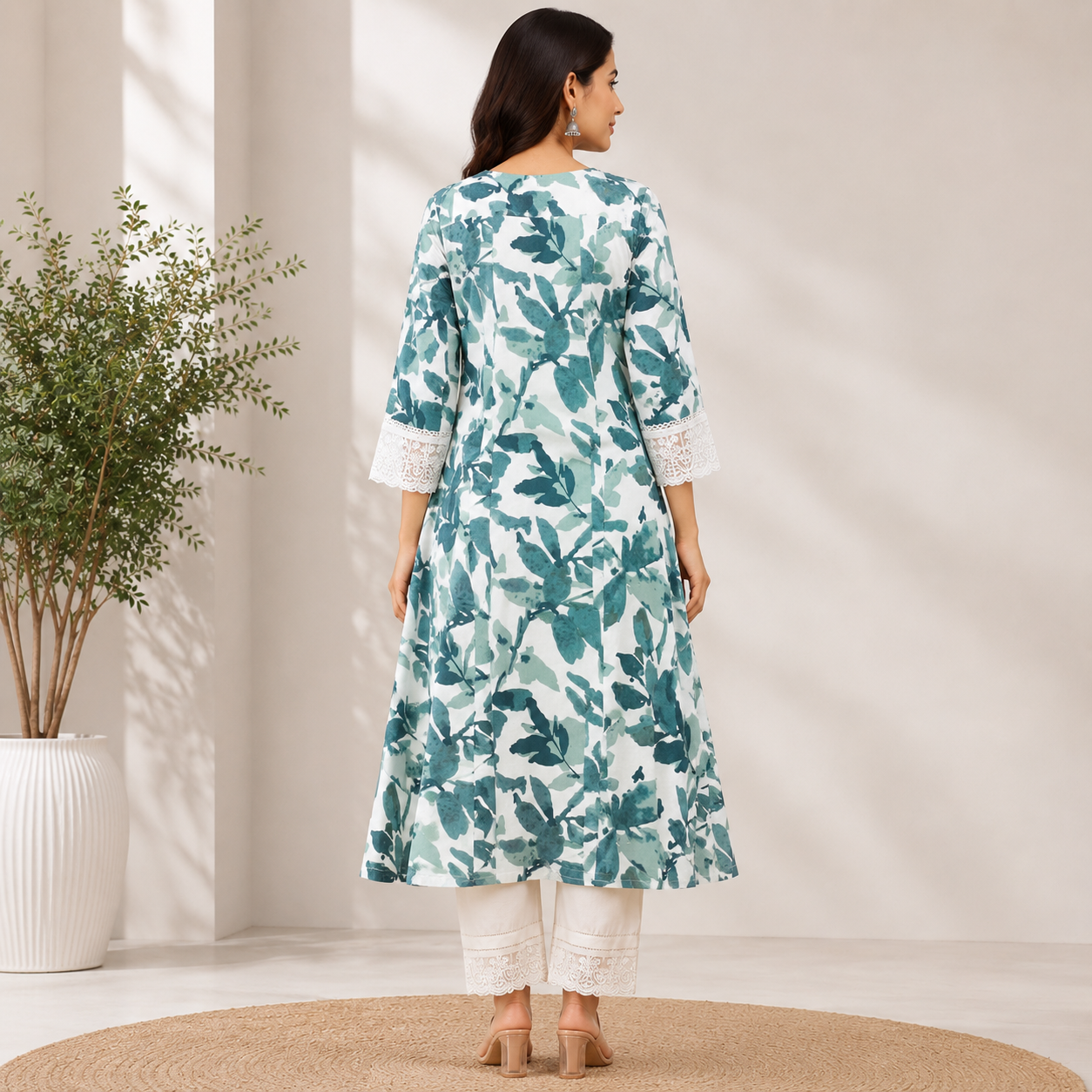 White and sage green floral printed A-line kurta set featuring delicate lace sleeve detailing and coordinated embroidered pants for a fresh, elegant look.