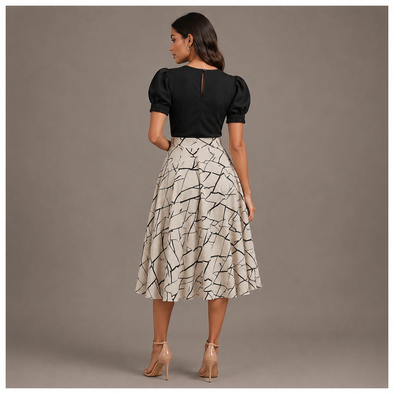 Elegant black and ivory midi dress featuring puff sleeves and an abstract printed flared skirt for a classy modern look.