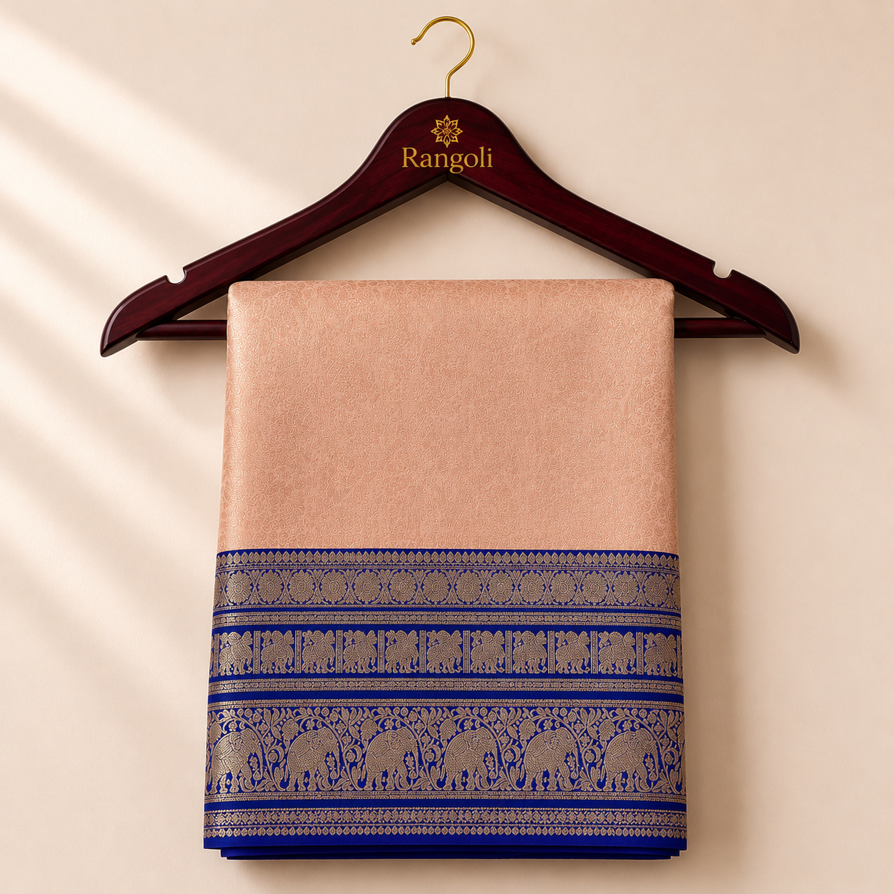 Kanchipattu peach gold saree with intricate zari weaving and a regal royal blue elephant motif border for a luxurious traditional look.