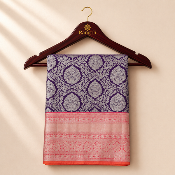 Kanchipattu deep purple saree with intricate silver zari floral weaving and a rich peach-pink border for a regal festive look.
