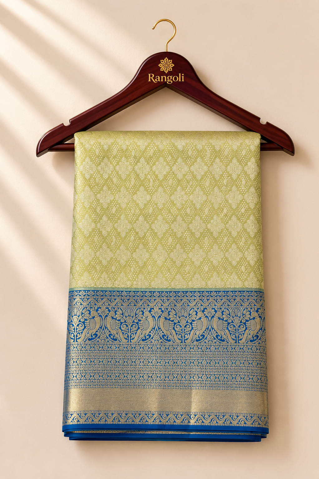 Kanchipattu lime gold saree with intricate zari weaving and a royal blue peacock motif border for a rich festive look.