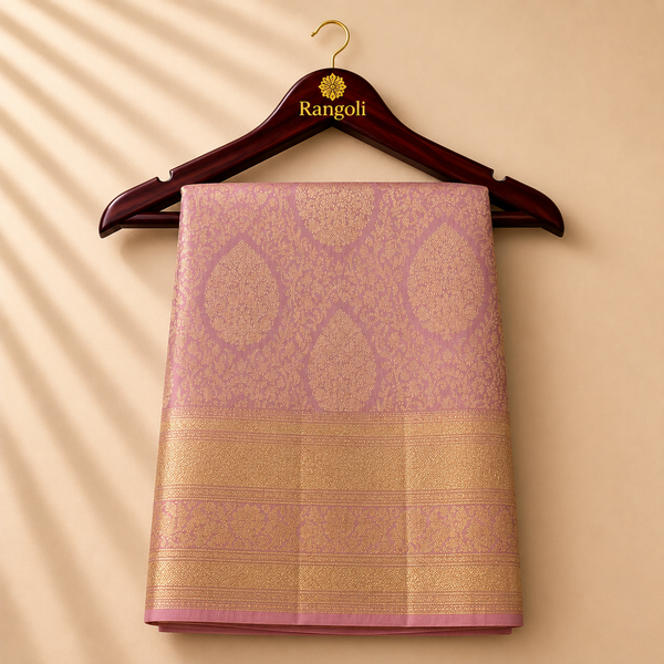 Mauve rose Kanchipattu saree with rich gold zari woven motifs and a luxurious traditional border for a timeless festive look.auve rose Kanchipattu saree with rich gold zari woven motifs and a luxurious traditional border for a timeless festive look.