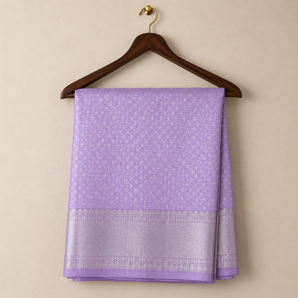 Elegant lilac Kanchipattu saree adorned with delicate zari woven motifs and a rich silver zari border for a graceful festive look.