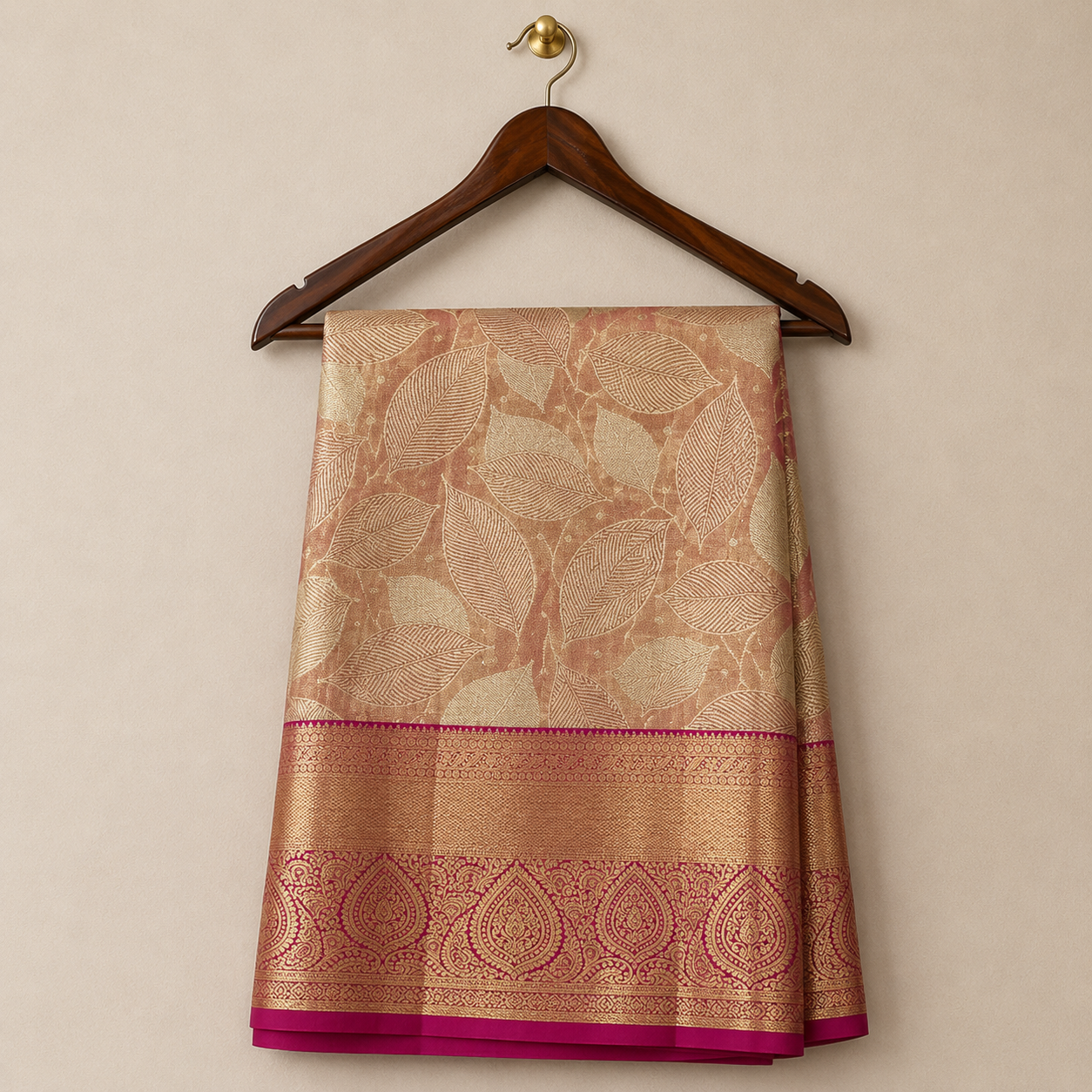 Elegant peach-gold Kanchipattu saree featuring rich leaf-pattern zari weaving with a grand wine zari border for a luxurious festive look.