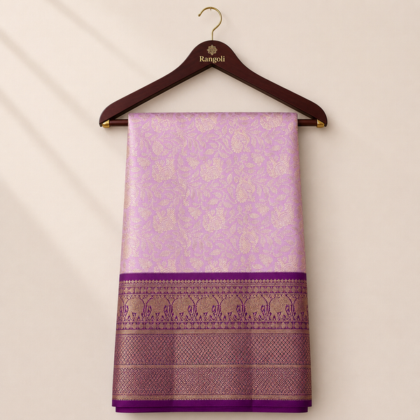 Elegant lavender Kanchipattu silk saree featuring intricate floral zari weaving with a rich deep purple zari border for a graceful festive look.