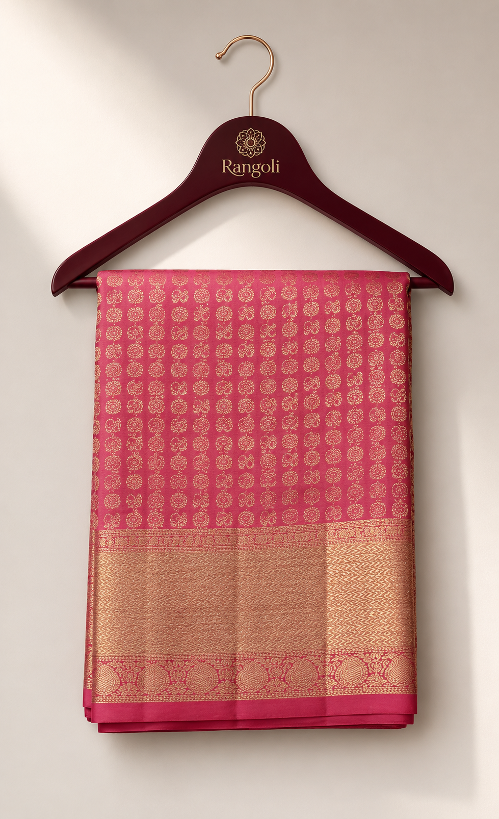 Coral pink Kanchipattu saree featuring intricate gold zari woven motifs with a rich traditional zari border.