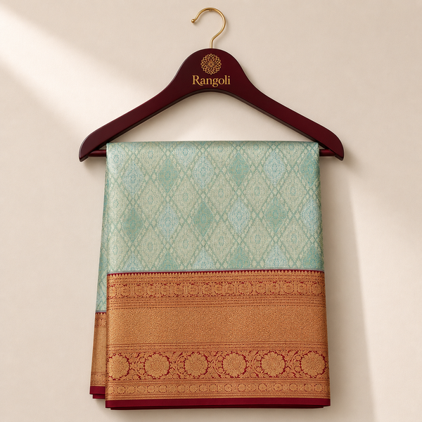 Seafoam green Kanchipattu saree with intricate gold weaving and a rich deep red zari border.